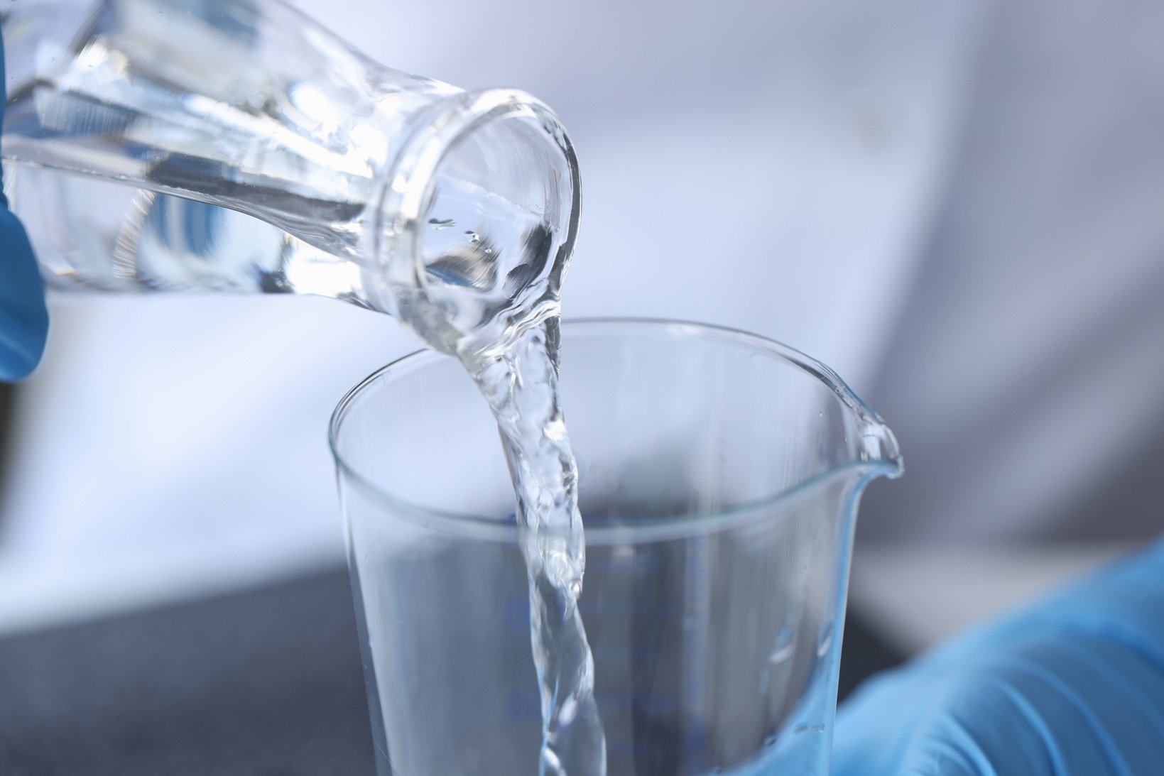 Clear Liquid Is Poured from Glass Bottle