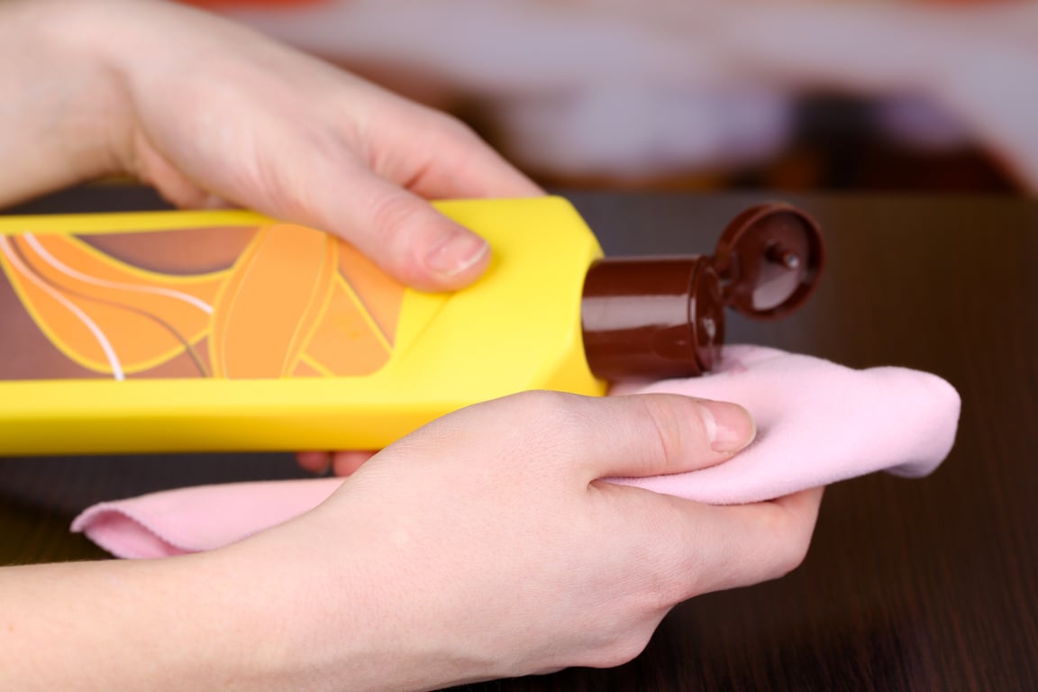 Hand Cleaning Wooden Table with Furniture Polish